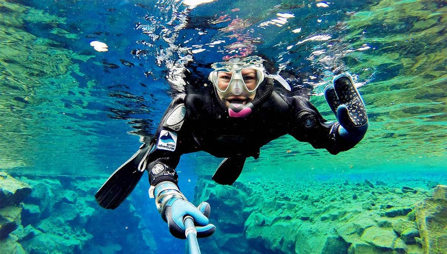 Snorkeler diving in Silfra Fissure in Thingvellir National Park, one of the most popular guided tours from Reykjavik, Iceland.
