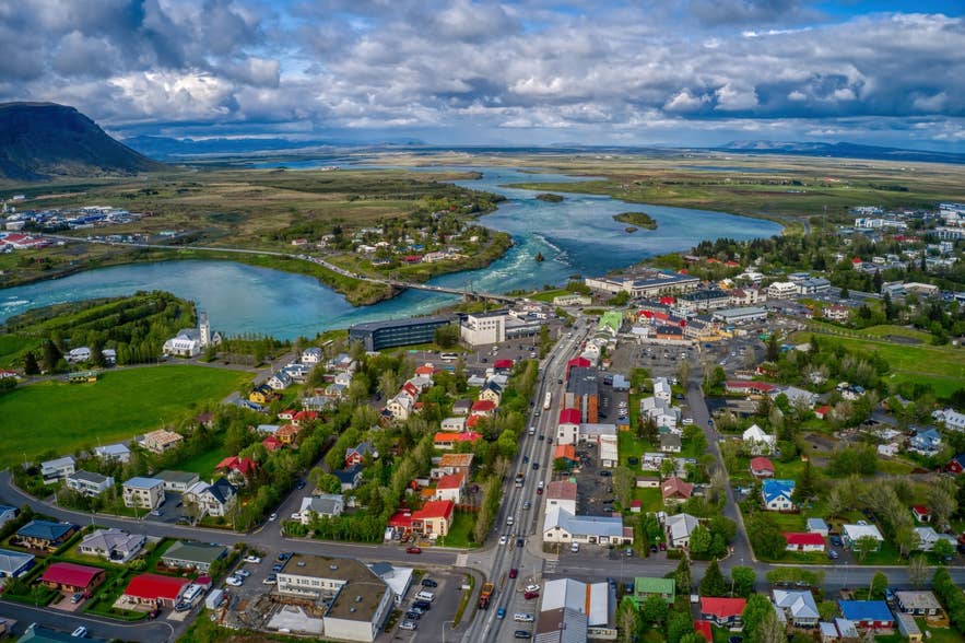 Aerial view of Selfoss Town in South Iceland, showing the Olfusa River, Olfusarbru Bridge, and surrounding countryside.