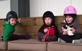 A child waits for their indoor horse riding session.