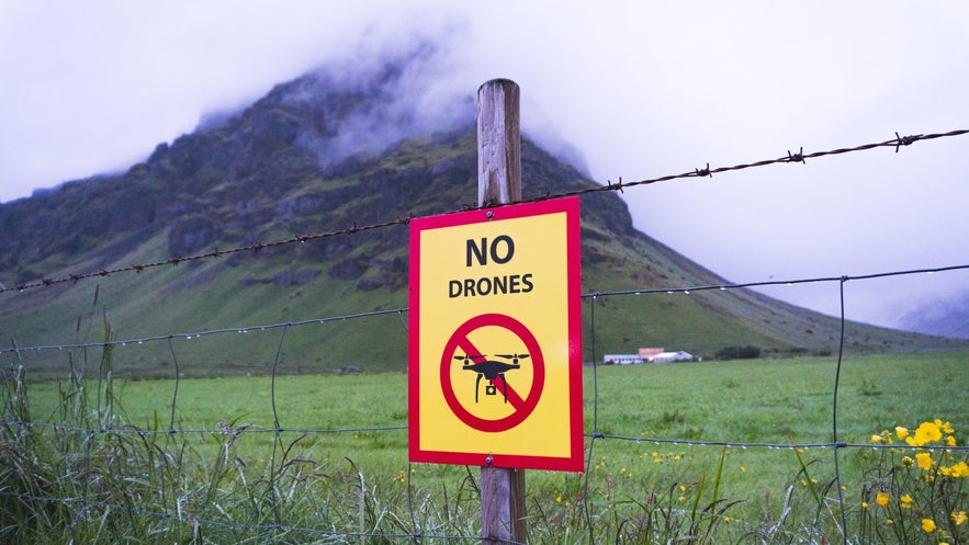 No drones sign near Skogafoss showing restricted zones for flying drones in Iceland’s protected areas.