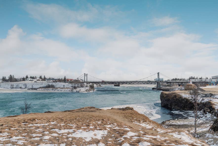 Winterliche Ansicht der Ölfusarbru bei Selfoss, einer historischen Hängebrücke über den Ölfusa-Fluss im Süden Islands.