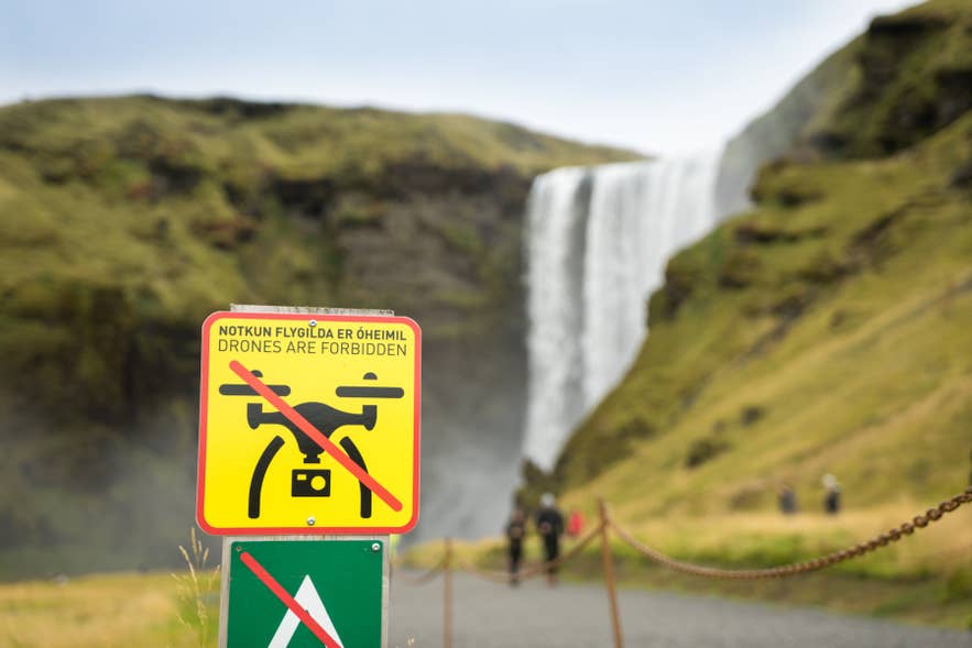 No drone sign near Skogafoss Waterfall on Iceland’s South Coast indicating drones are prohibited. No drone sign near Skogafoss Waterfall on Iceland’s South Coast indicating drones are prohibited.