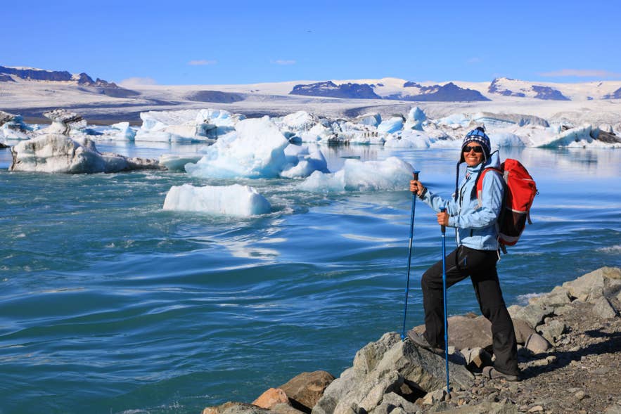 Traveler standing near icebergs at Jokulsarlon Glacier Lagoon in Vatnajokull National Park, South Iceland.