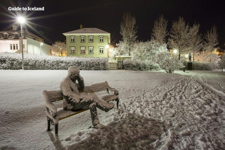 A snow covered statue by the pond in Reykjavik