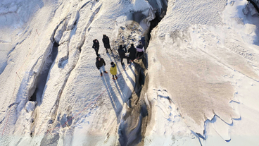 A group of people are seen exploring a crevasse on top of Langjokull glacier.