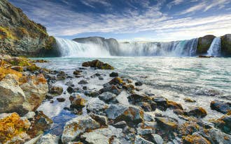 Godafoss Waterfall in summer under a bright blue sky in North Iceland.