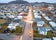 Aerial view of central Grindavik, Iceland, with Reykjanes mountains and houses along Víkurbraut Street at dusk.