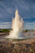 The Strokkur geyser bursts high into the air at the Geysir geothermal area in the Haukadalur valley.