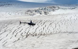 Un hélicoptère survole un glacier gelé lors d'une excursion en Islande.