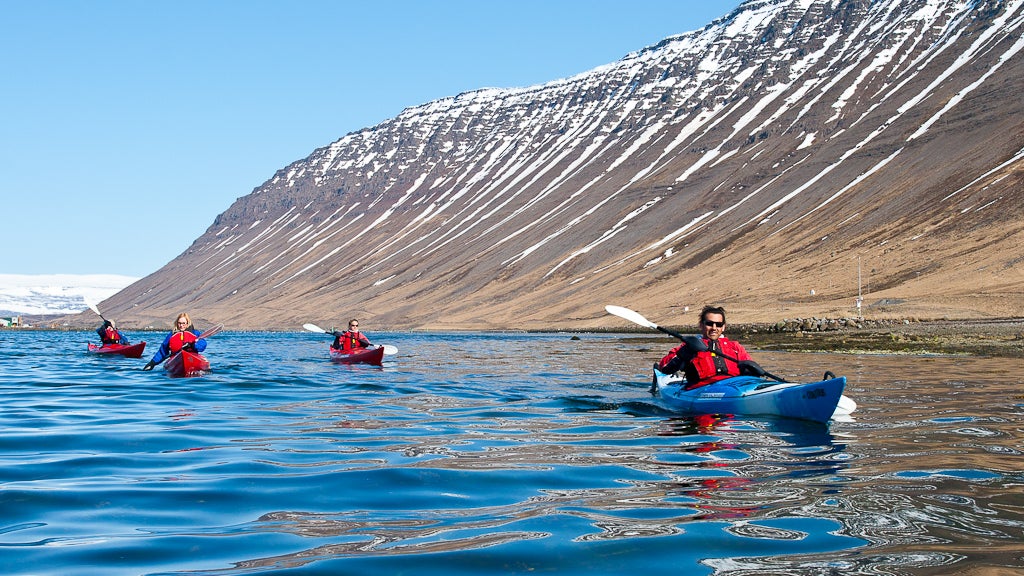 See snowy mountains while paddling in the Westfjords of Iceland.
