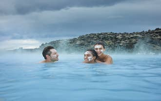 Three people enjoying a dip in the world-famous Blue Lagoon of Iceland.