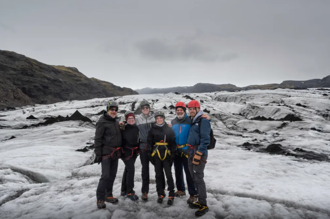 Ready to embrace the chill – the group stands fully geared for their Solheimajokull adventure.