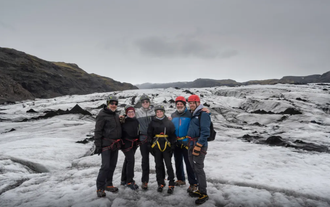 Ready to embrace the chill – the group stands fully geared for their Solheimajokull adventure.