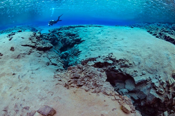 A diver underwater at the Silfra fissure, known for its crystal-clear waters.