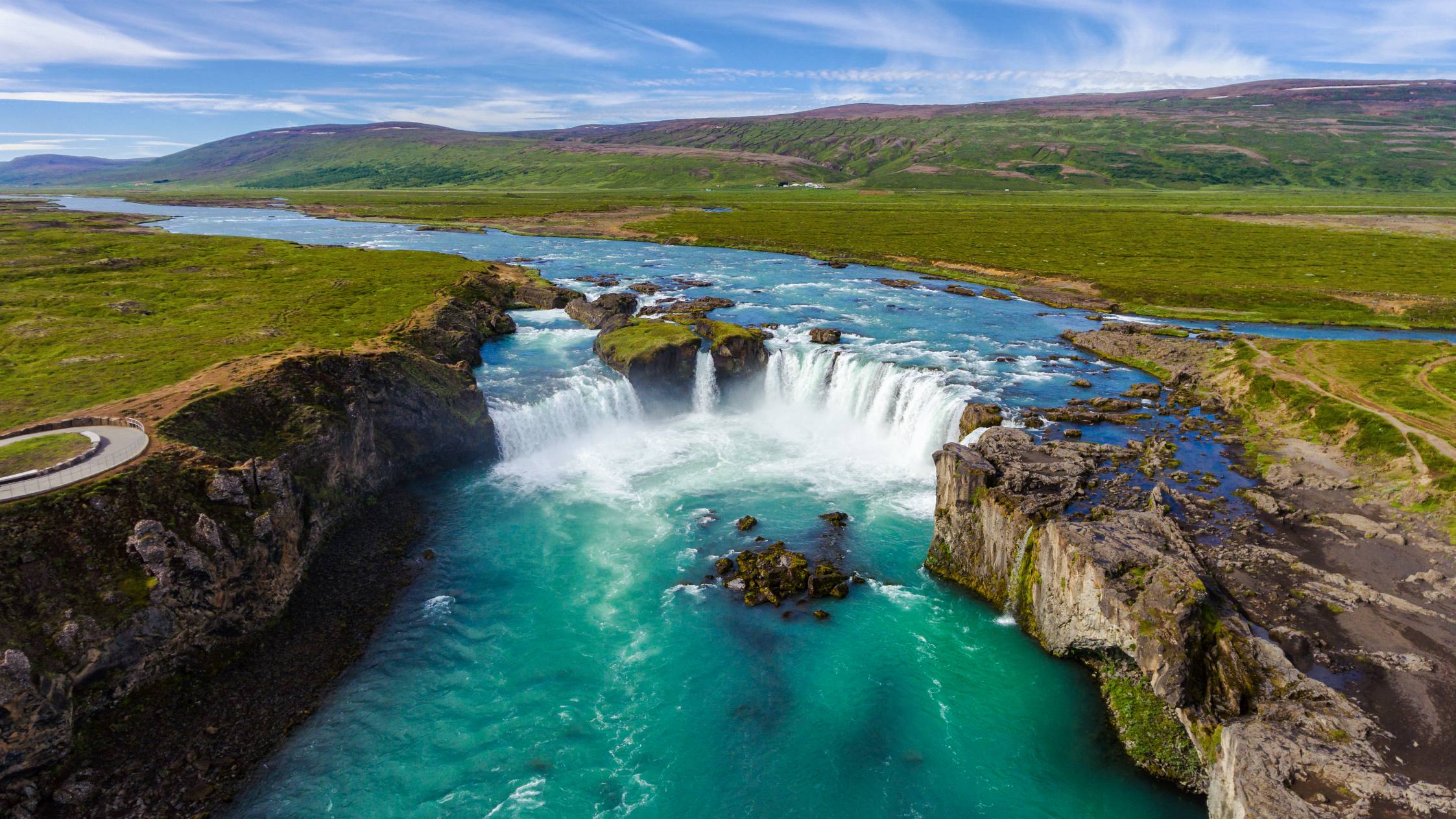 Godafoss Waterfall with turquoise river and cliffs seen on a Lake Myvatn tour from Akureyri.