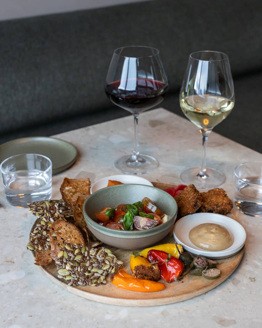 Ylja Restaurant sharing platter at Laugaras Lagoon Iceland with local appetizers, bread, dips, and wine in a modern Icelandic dining setting Ylja Restaurant sharing platter at Laugaras Lagoon Iceland with local appetizers, bread, dips, and wine in a modern Icelandic dining setting