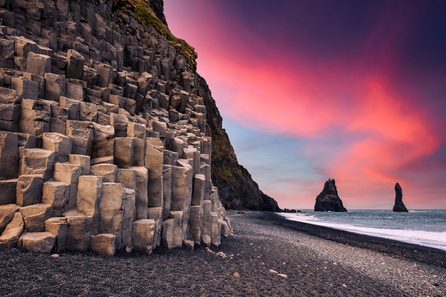 Zuid-IJsland heeft veel geologische kenmerken, zoals de rotsformaties van Reynisdrangar en de zeshoekige kliffen bij het strand van Reynisfjara.
