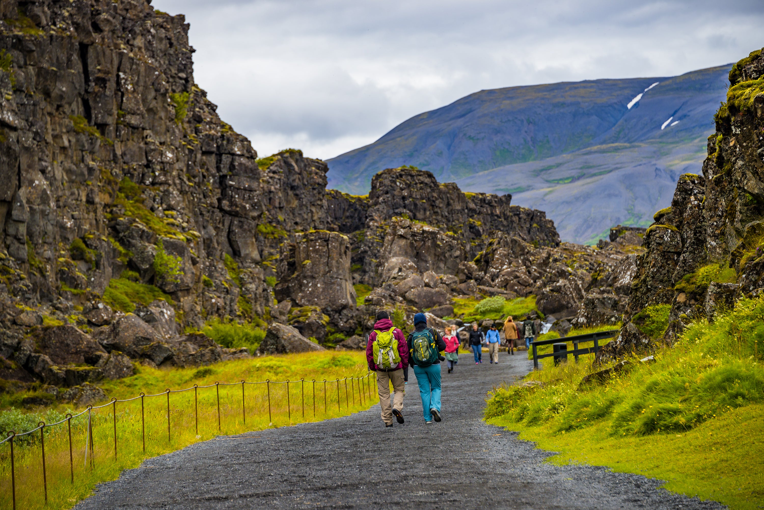 Hikers walk through Thingvellir Rift Valley showcasing tectonic plates on a grand Golden Circle tour.