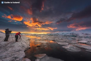 Tourists taking pictures of the icebergs floating on the Jokulsarlon glacier lagoon.