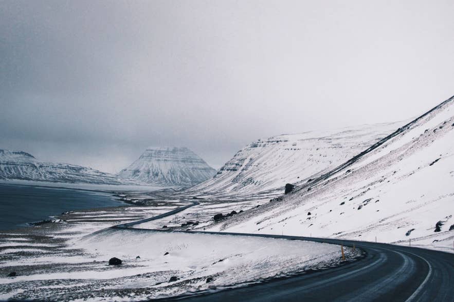 An open road stretching across a windswept Icelandic landscape