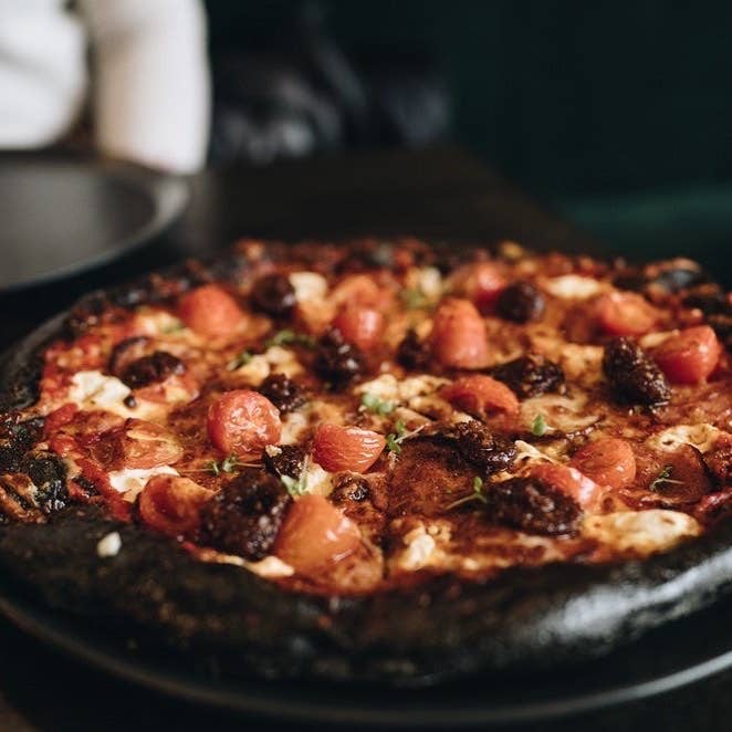 La crosta della pizza della pizzeria Black Crust è, com’era prevedibile, molto scura La crosta della pizza della pizzeria Black Crust è, com’era prevedibile, molto scura
