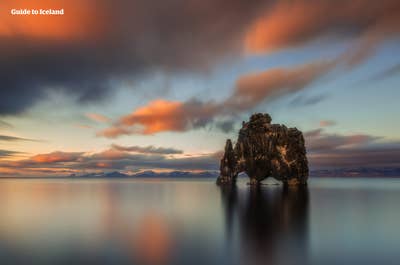 La impresionante formación rocosa de Hvitserkur emerge del océano al atardecer.