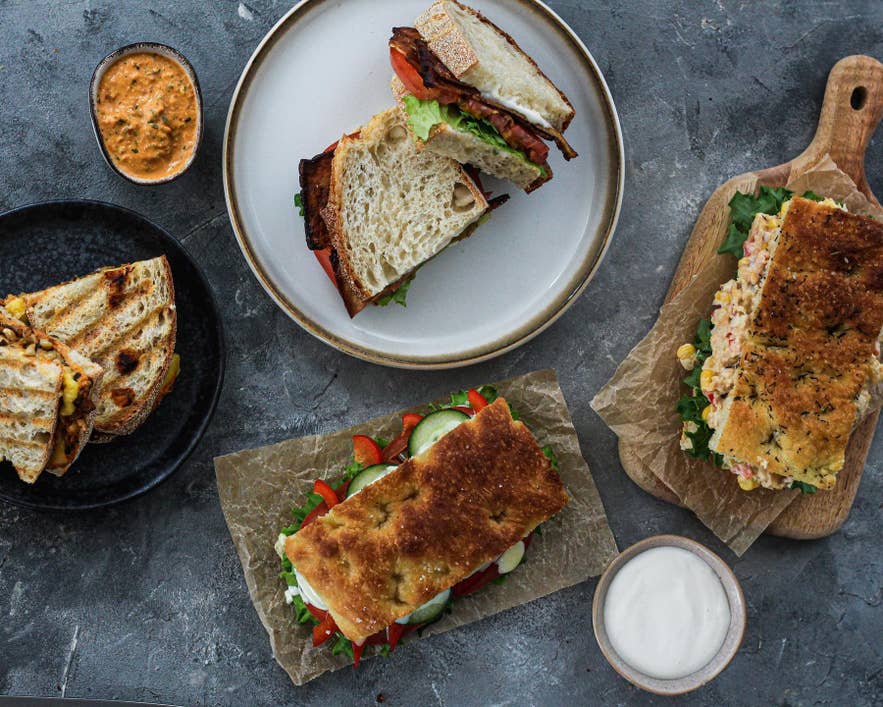 Plantan Cafe Reykjavik vegan sandwiches and wraps with fresh vegetables and sauces on rustic plates top view