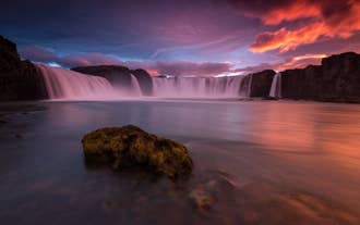Godafoss Waterfall cascades into a horseshoe-shaped cliff in North Iceland.