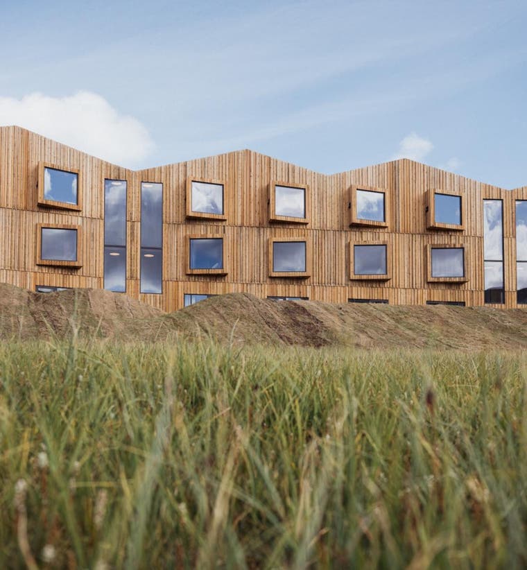 Highland Base Kerlingarfjoll Hotel with modern wood exterior set in grassy Highland landscape in Iceland