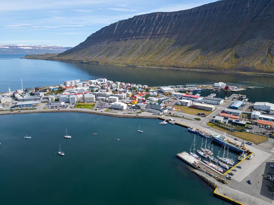 Aerial view of Isafjardardjup fjord, a prime example of fjords in Iceland, featuring a coastal town and mountain peaks.