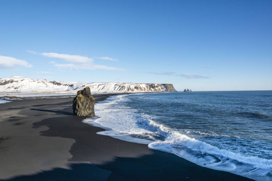 Reynisfjara black sand beach on Iceland's South Coast with Reynisdrangar sea stacks in the distance Reynisfjara black sand beach on Iceland's South Coast with Reynisdrangar sea stacks in the distance