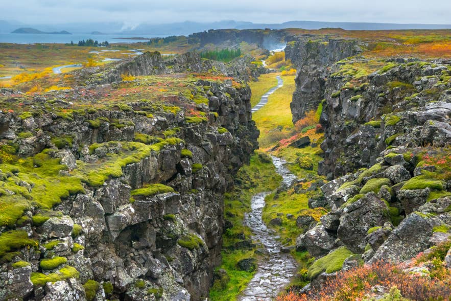 Almannagja rift in Thingvellir National Park shows the rocky gap between tectonic plates with a walking path through the valley in Iceland.