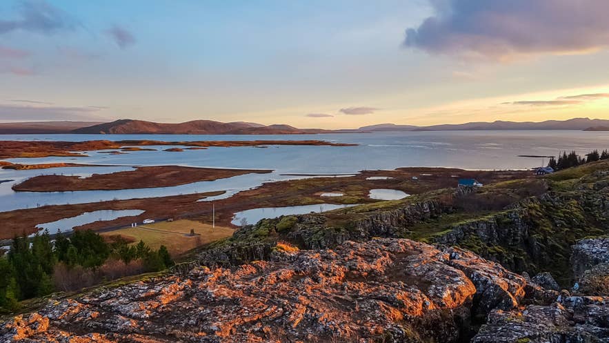 View over Thingvellir National Park with rift valley cliffs and Lake Thingvallavatn in the background during sunset in Iceland.