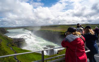 A visitor watches Gullfoss Waterfall thunder into its canyon along the Golden Circle.