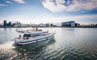 The harbor cruise vessel on Faxafloi Bay with the Reykjavik city skyline.
