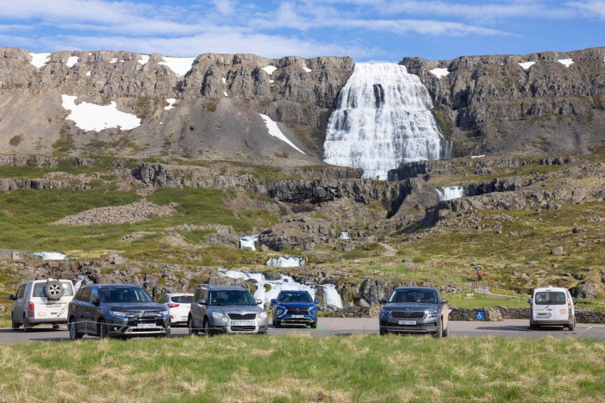 Cars parked near Dynjandi Waterfall in Iceland’s Westfjords