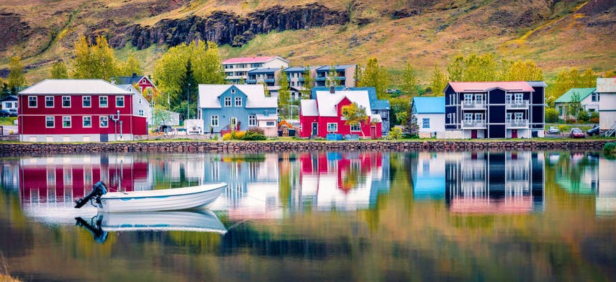 Colorful Icelandic village reflected on calm summer waterfront