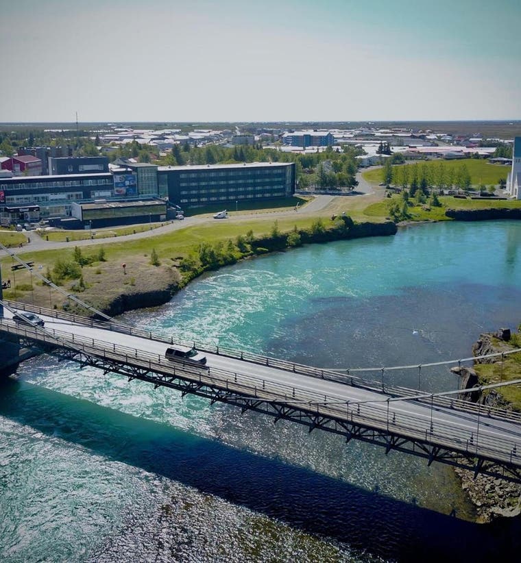 Aerial view of a hotel area by a river and bridge, a stay that's ideal for travelers planning a 7-day Iceland trip.