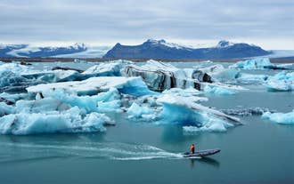 Jökulsárlón gletsjerlagune met drijvende ijsbergen en kalm, spiegelend water in Zuid-IJsland.