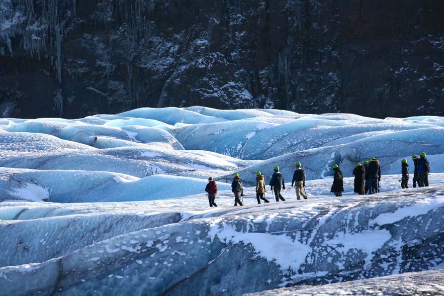 Guided group walking in single file across Vatnajokull Glacier, following the rules that apply inside the national park.