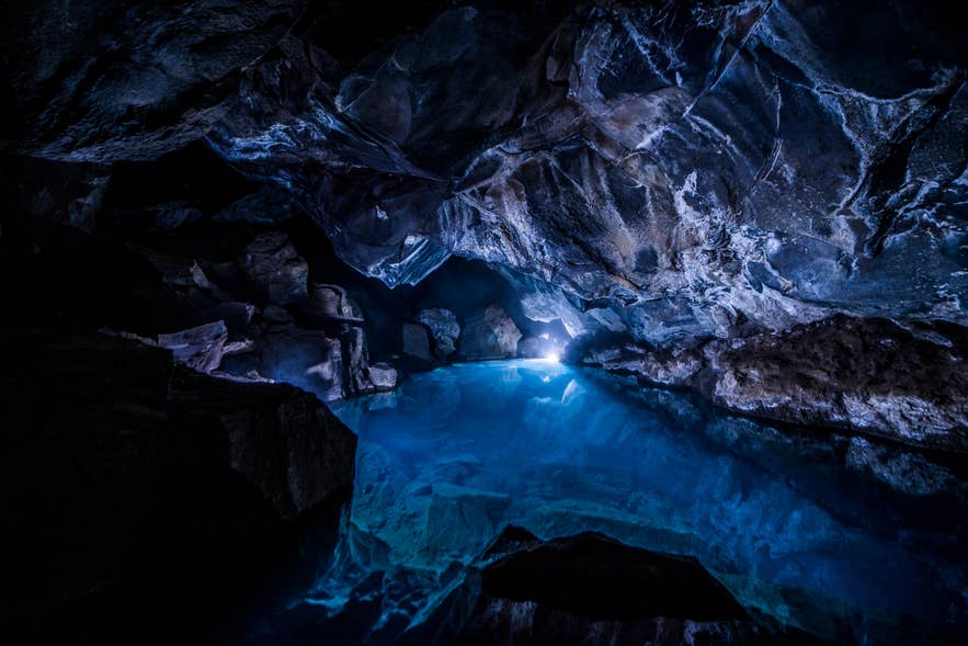 Still blue meltwater pool inside a dark ice cave, the kind of water the glacial river flow records measure.