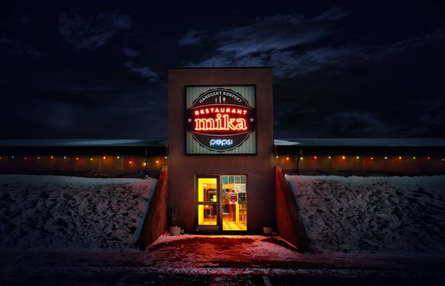 The illuminated exterior of Restaurant Mika at night in the village of Reykholt on the Golden Circle in Iceland.