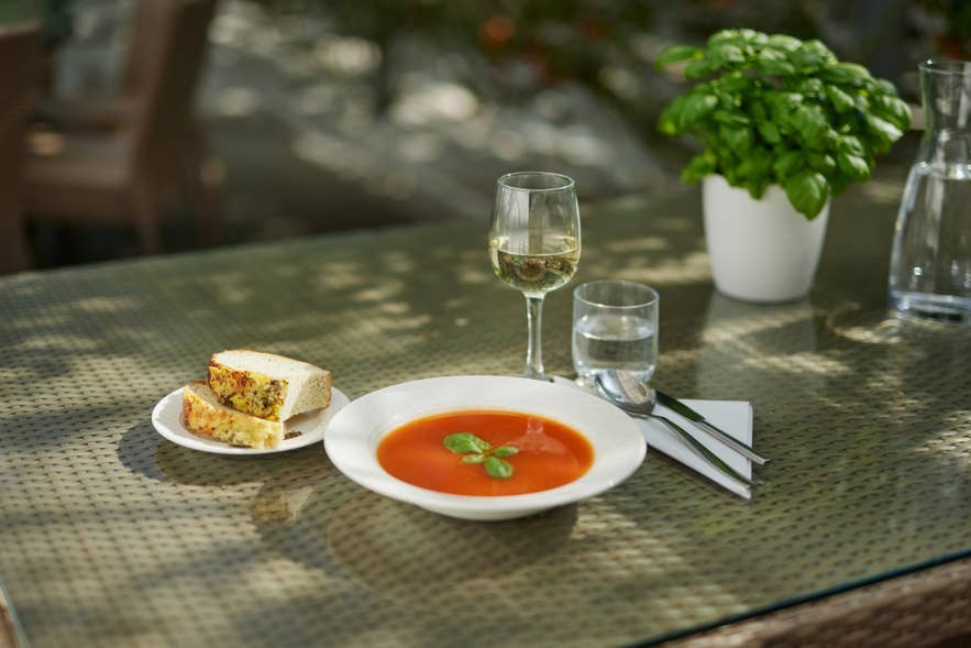 A bowl of fresh tomato soup with basil served inside the greenhouse at Fridheimar tomato farm on the Golden Circle in Iceland.