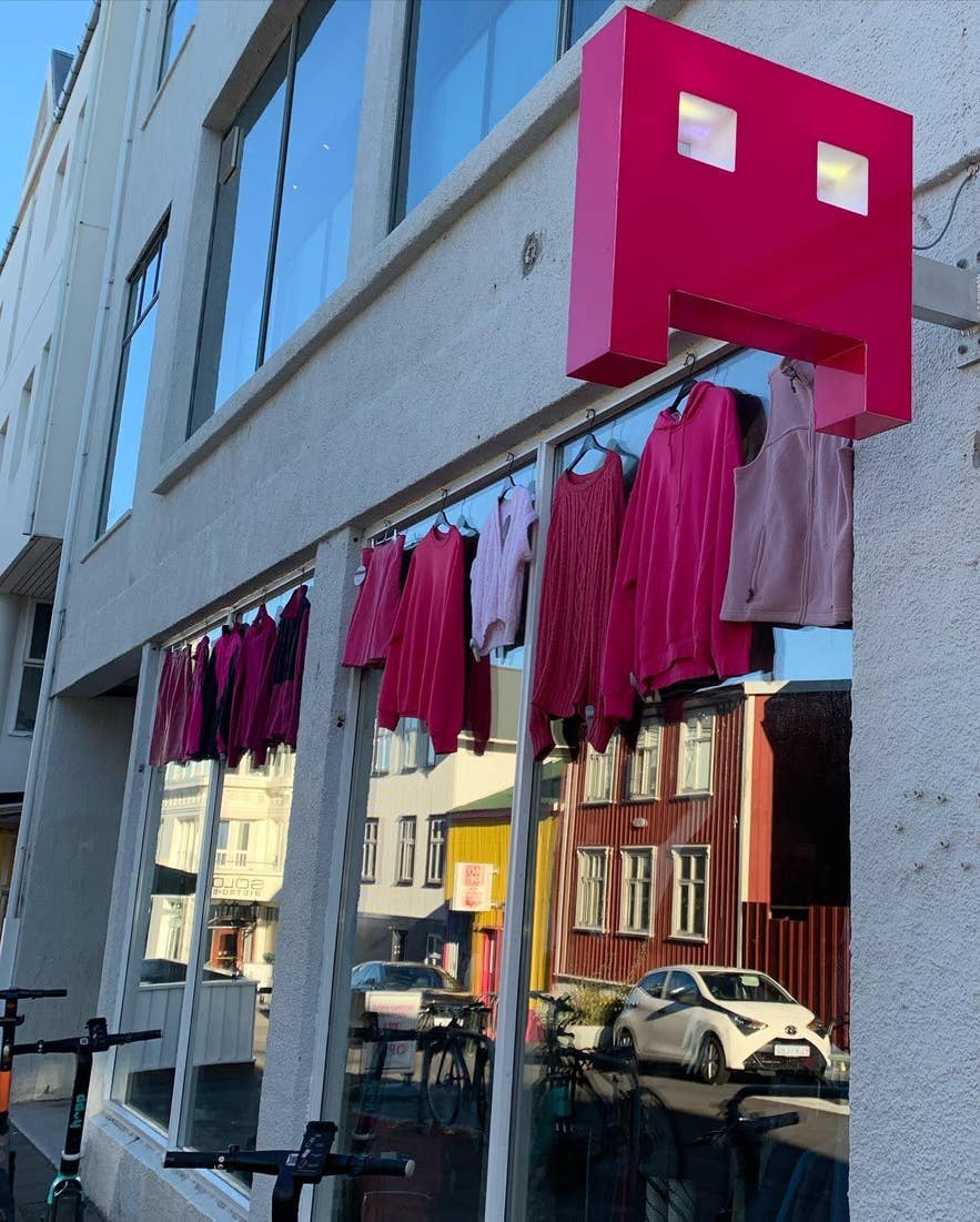 Pink clothing displayed outside Wasteland vintage store in Reykjavik beneath a bright pink storefront sign on a sunny street. Pink clothing displayed outside Wasteland vintage store in Reykjavik beneath a bright pink storefront sign on a sunny street.
