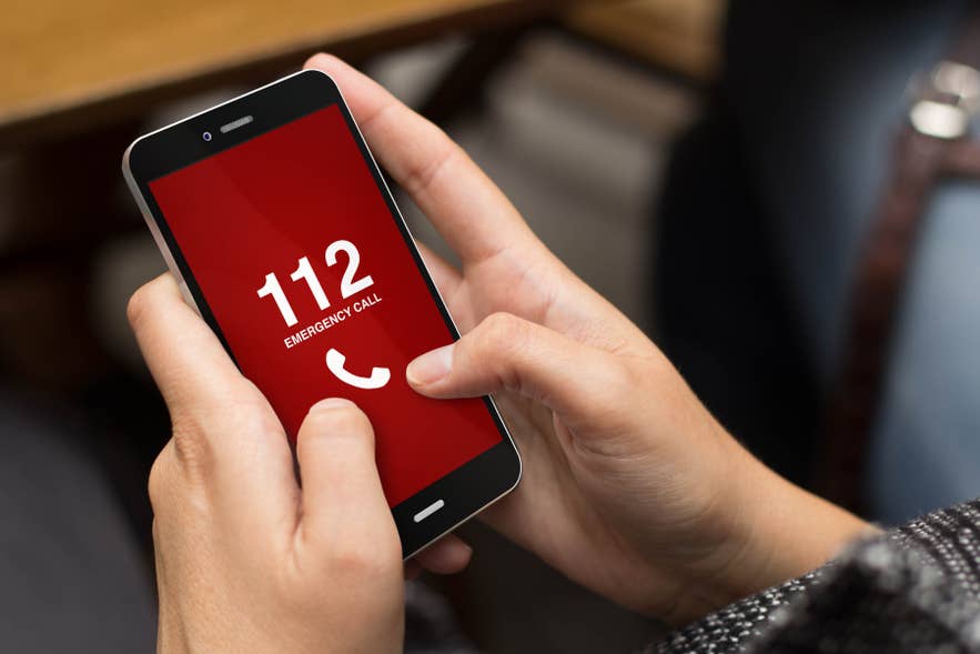 Ein Reisender wählt Islands Notrufnummer 112 auf einem Handy.