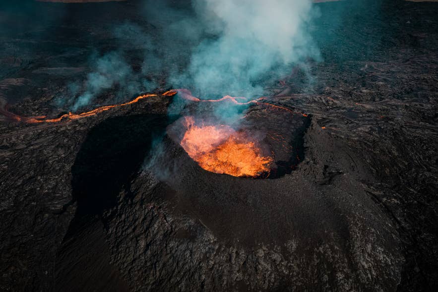 Lava crater glowing with molten lava during a volcanic eruption in Iceland.