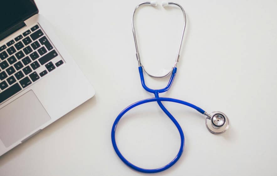 Stethoscope beside a laptop on a desk for healthcare assistance in Iceland.