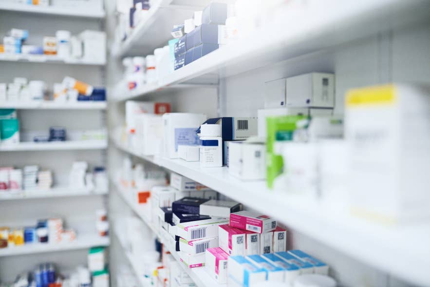 Shelves stocked with prescription medicine inside a pharmacy.