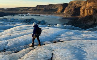 A hiker in winter gear standing on Solheimajokull Glacier on Iceland's South Coast.