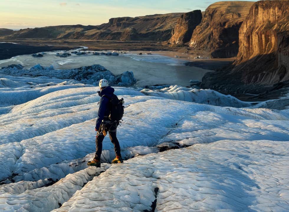 A hiker in winter gear standing on Solheimajokull Glacier on Iceland's South Coast.